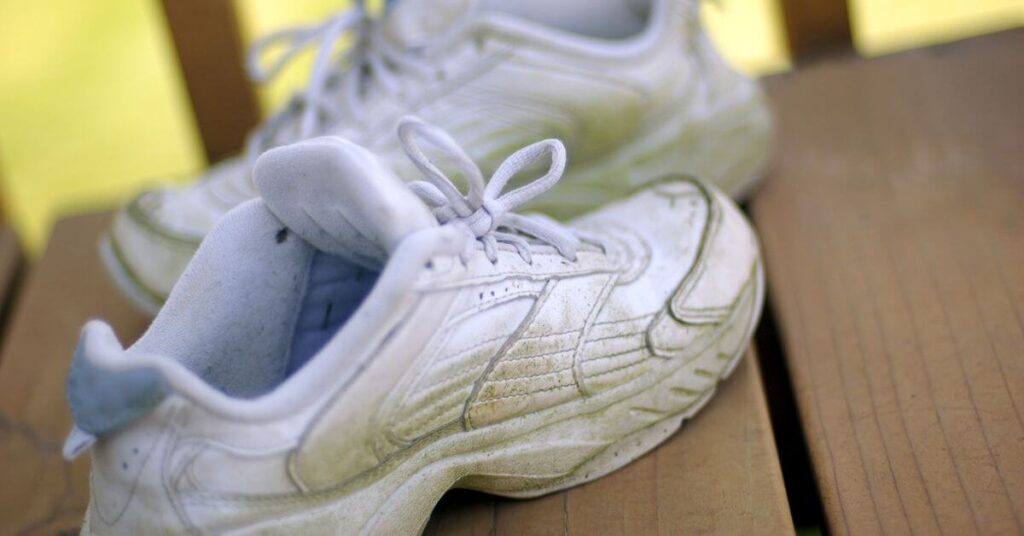 white tennis shoes for women on a wooden platform