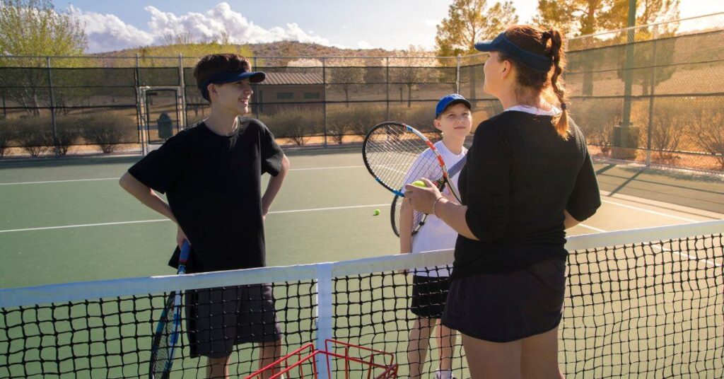 A mentor teaching two young tennis players evoking the same feeling when using the best tennis apps