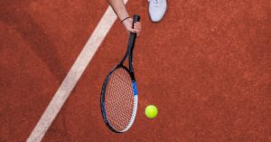 A ball bouncing towards to the tennis racket for the difference between tennis and lawn tennis