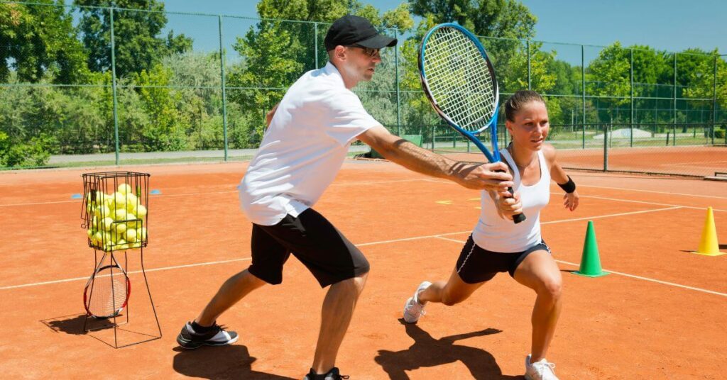 A coach and a young tennis player training outdoors, a perfect reflection of what a tennis coach online can do as well