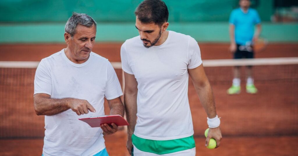 A middle aged man being trained by a coach outdoors which could be possible by having a tennis coach online
