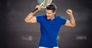 A happy player winning a game in a blue top showing how tennis mindset tips work