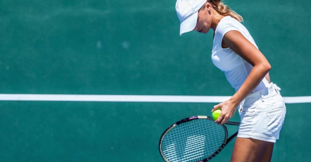 A player saying her self affirmation before serving, one of the best tennis mindset tips to do