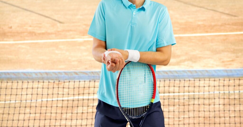 A tennis player in blue in pain in need of tennis wrist exercises