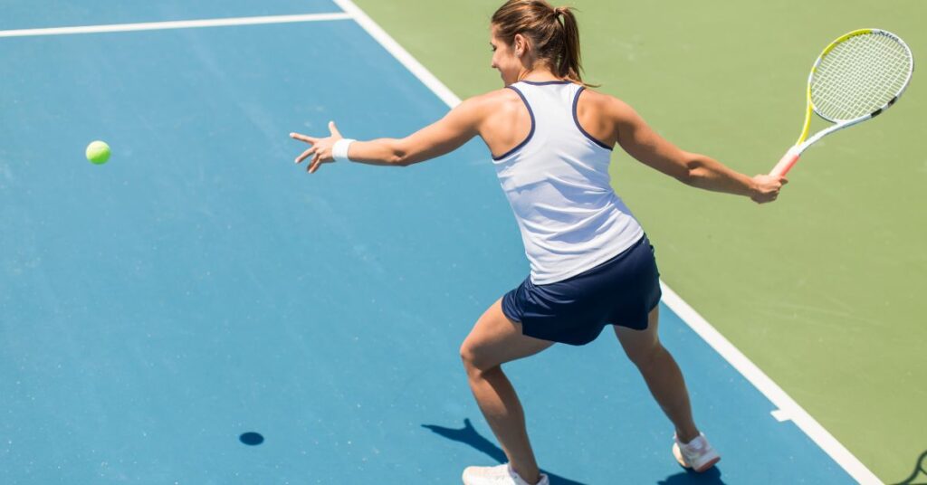 A tennis player on a blue colored court about to hit an incoming ball to try one of the best tennis facts at play
