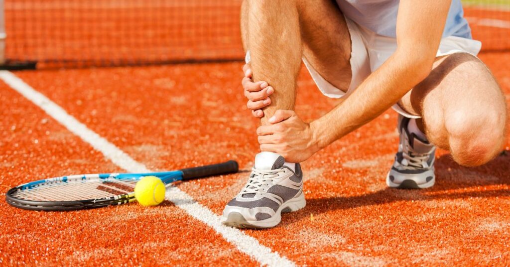 A person having foot pain, one of the tennis common injuries