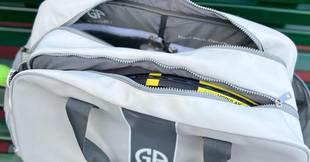 A white opened duffle bag for tennis rackets, one of the best tennis accessories to have