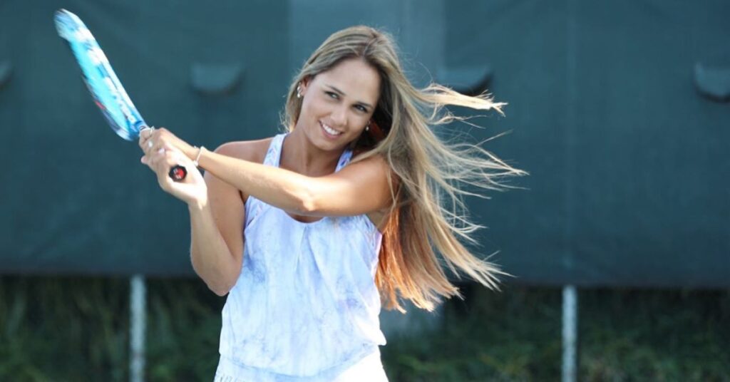 A tennis player happily hitting forming a hitting stance after knowing how tennis ranking works