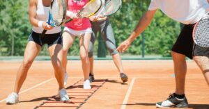 A couple of players and a tennis coach working on tennis footwork drills at home court